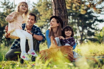 Young caucasian family having a picnic on a grassy field in nature