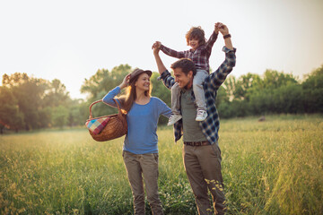 Young caucasian family having a picnic on a grassy field in nature