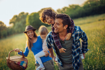 Young caucasian family having a picnic on a grassy field in nature