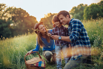 Young caucasian family having a picnic on a grassy field in nature