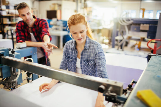 Middle Aged Man And A Young Woman Working In A Printing Press Office