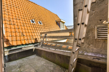 an orange tiled roof on a house in the middle of town, taken from inside looking out to the outside