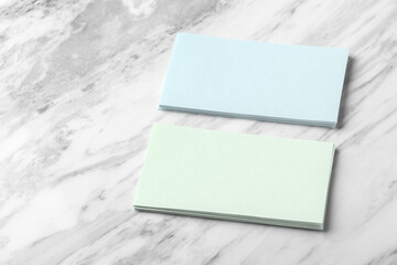Pastel blue and green business card on white marble background