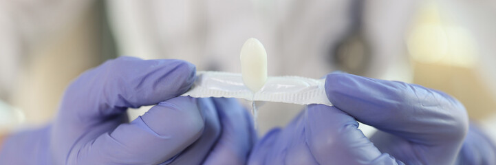 Doctor hands in gloves holding opened suppositories for anal or vaginal use