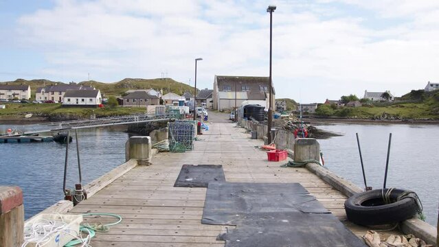 Static shot of the pier and docked fishing boats on the Isle of Scalpay.