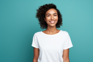 Close up of a young adult 30s age woman smiling and wearing a white t-shirt on a turquoise background. Healthy face skin care beauty, skincare cosmetics, dental.