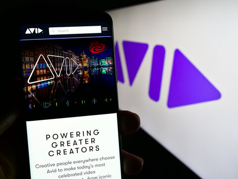 Stuttgart, Germany - 08-29-2023: Person holding smartphone with web page of US software company Avid Technology Inc. on screen in front of logo. Focus on center of phone display.