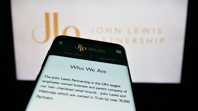 Stuttgart, Germany - 08-29-2023: Mobile phone with website of retail company John Lewis Partnership plc on screen in front of business logo. Focus on top-left of phone display.