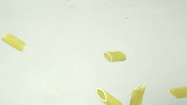Slow motion shot of Pasta falling in Water