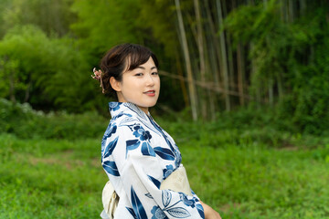 山間にたたずむ浴衣の女性
