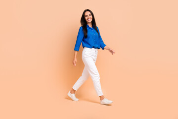 Fototapeta na wymiar Full length profile side photo of cheerful lovely lady dressed blue trendy outfit going office center isolated on beige color background