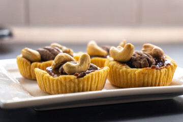 tartlet with caramel and nuts on a white plate. pecan. cashew.food concept. dessert. bakery. diet