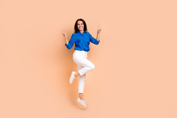 Fototapeta na wymiar Full length photo of cheerful positive girl wear trendy outfit demonstrate two hands v-sign good mood isolated on beige color background