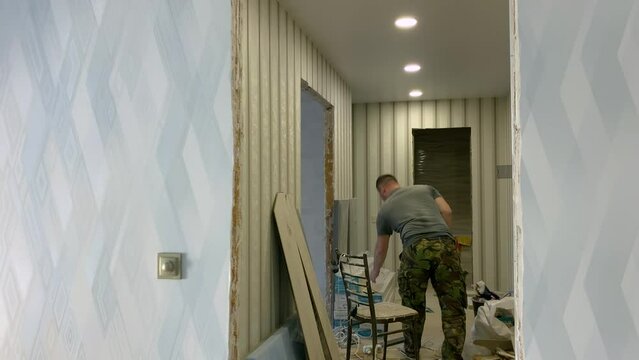 Repair of apartments. Cutting laminate with a jigsaw. Repairs. Apartment renovation, final stage. The builder cuts the laminate for laying on the floor with an electric jigsaw. High quality 4k footage