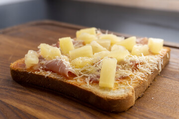 toast with ham and pineapple on a wooden background. sandwich. mini pizza. top view