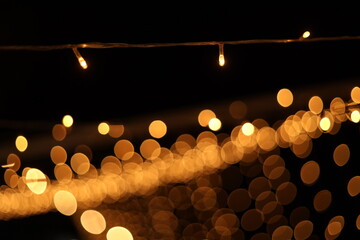 Blurred golden festive lights. Blurred backdrop for holidays and parties. Christmas Party concept.