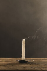 Fototapeta premium Vertical image of extinguished candle with copy space on grey background