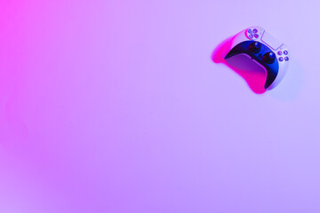 Composite of video game pad and copy space on neon background
