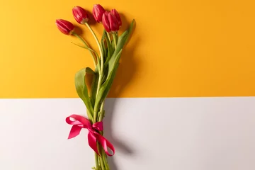 Keuken spatwand met foto Bunch of red tulips and copy space on orange and white background © vectorfusionart
