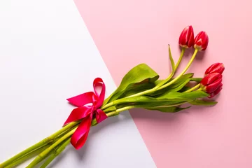 Foto op Plexiglas Bunch of red tulips and copy space on pink and white background © vectorfusionart