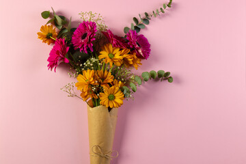 Bunch of pink and yellow flowers in paper with copy space on pink background