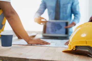 interracial group of architects and engineers on meeting on blueprint for project work in, construction workers on a construction site