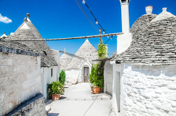 Old street with trulli white houses in Alberobello, Italy 