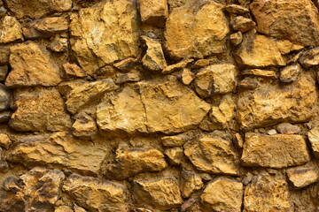 A wall of large and small brown stones. High quality photo