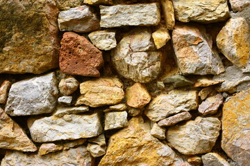 A wall of stones of different sizes and colors. High quality photo