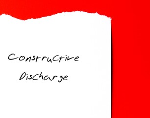 Torn office paper with handwritten text Constructive Discharge (Constructive Dismissal) where...