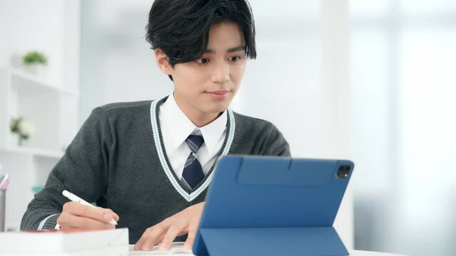 タブレットで勉強する男子学生