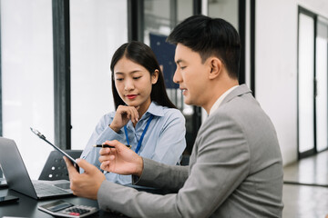 Asian young business people discussing on performance revenue in meeting. businessman working with co-worker team. financial adviser analysing data with investor.