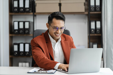 Obraz premium Male writes information businessman working on laptop computer writing business plan while sitting in office.