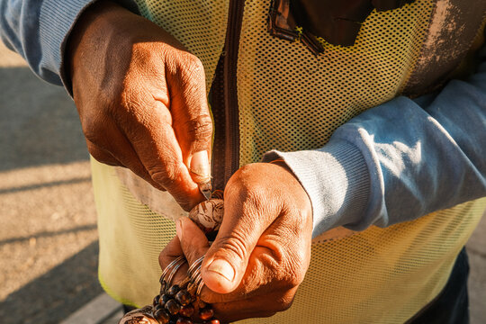 Namibian man carving a makalani palm tree fruit to make a key ring. Makalani key rings are common souvenirs sold all over Namibia.