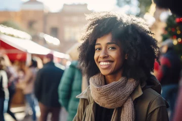 Poster Young happy smiling african american woman in winter clothes at street Christmas market in Sidney © Jasmina