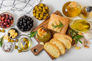 Ciabatta and olives. Fresh italian ciabatta bread with herbs, olive oil,parmesan and pesto sauce, olives on wooden background, top view, copy space.Flatley. Place for text. copy space.
