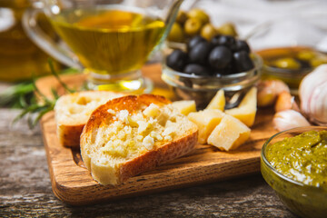 Ciabatta and olives. Fresh italian ciabatta bread with herbs, olive oil,parmesan and pesto sauce, olives on wooden background, top view, copy space.Flatley. Place for text. copy space.