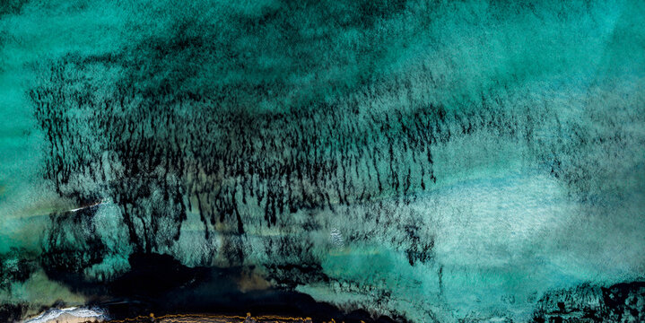 Aerial view vibrant turquoise ocean at the beach of Es Trenc, Majorca, Spain
