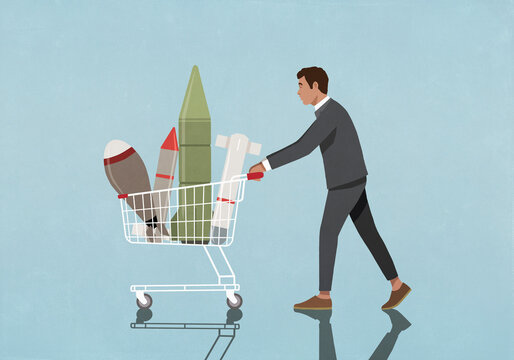 Businessman buying rockets and missiles in shopping cart
