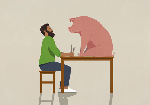Man with fork and knife staring at pig on dining table
