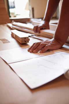 Close up of man's hands on flat pack furniture instructions
