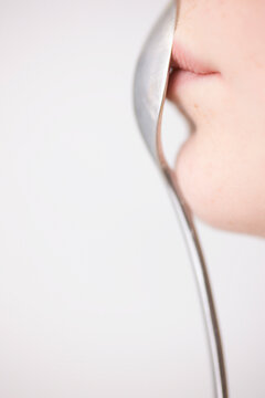 Woman Holding Spoon in front of Mouth
