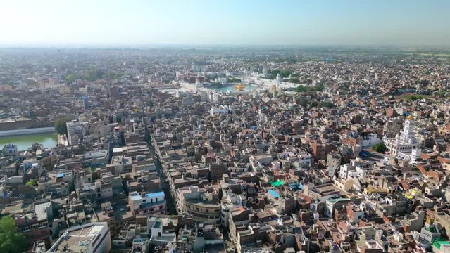 Amritsar, India: Aerial view of famous city in Punjab, iconic landmark The Golden Temple (Harimandir Sahib) - landscape panorama of South Asia from above