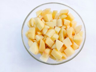 bowl of potato. Diced raw potatoes in a glass bowl on a white background. vegetables. cooking preparation. healthy living.
