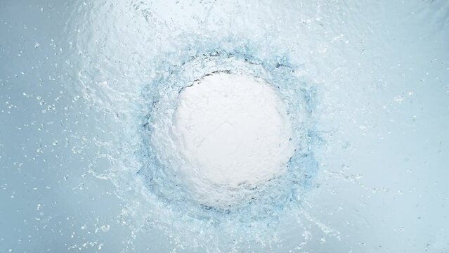 Super Slow Motion Shot of Round Water Splash on Light Blue Background at 1000fps.