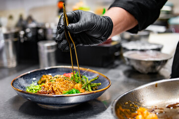 chef cooking Salad with funchoza, shrimp and vegetables in kitchen