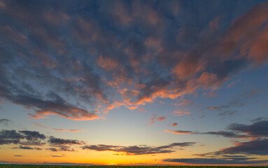Evening's Embrace: Blue Sky Illuminated by Orange-tinged Clouds