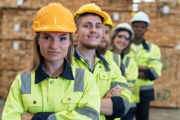 Group of male and female warehouse workers standing together with crossed arms and smiling in...