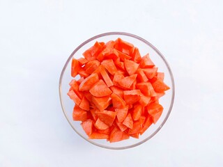 carrots in glass bowl. Slices of raw carrots in a glass bowl on a white background. vegetables. cooking preparation. healthy living.
