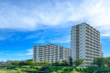 Fototapeta premium 青空の下、緑あふれる自然の中に立つ集合住宅